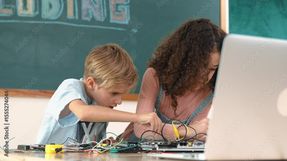 Poster diverse smart student working together to fix main board at stem class while looking at laptop scree
