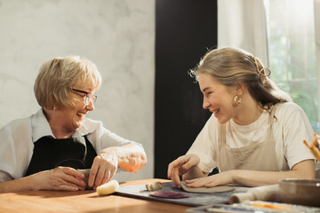 Senior woman and young potter creating clay art together