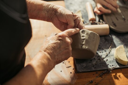 Senior potter creating clay vessel: embracing artistic passion in retirement
