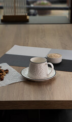 White beautiful handmade mug stands on light wooden table indoors