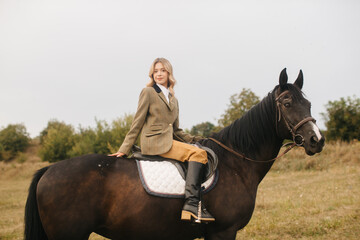 Young Woman Equestrian Riding a Beautiful Dark Horse in the Countryside