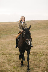 Young Woman Riding Black Horse in a Serene Open Field Landscape