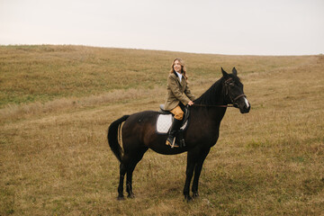 Person Riding a Black Horse in a Peaceful Grassy Countryside
