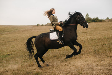 Young Woman Riding a Black Horse Galloping Across an Open Field
