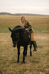 Woman Mounting a Horse in an Expansive Countryside Field