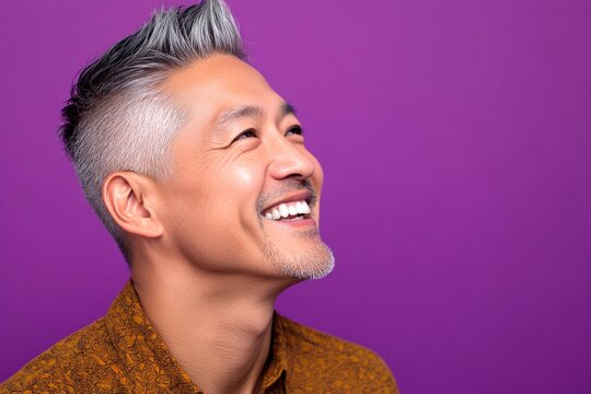 A chic and vibrant male with effortless elegance. Purple solid background. Classy men's spiky hair haircut - midlife asian man with short hair. Creative of style for aging men.