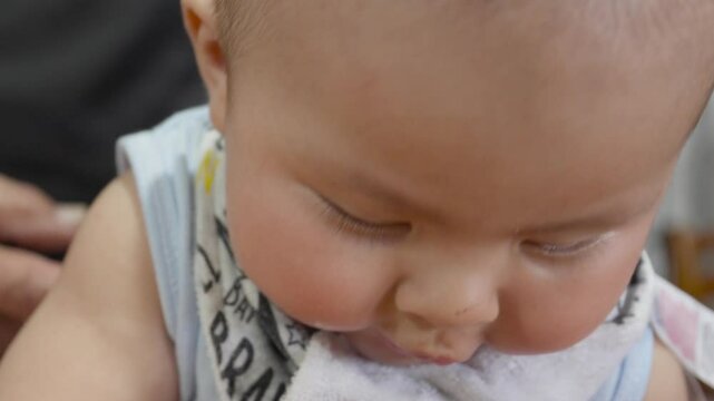 Chubby infant displaying playful expressions while receiving gentle cleaning, showcasing pure childhood joy and spontaneous moment of connection