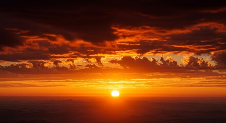 Fototapeta premium Fiery Orange Sunset with Dramatic Cloudscape over Hazy Horizon
