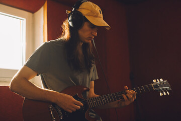 Musician playing electric guitar in recording studio