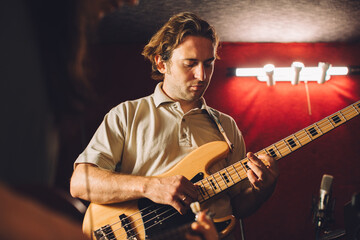 Obraz premium Musician playing bass guitar in recording studio