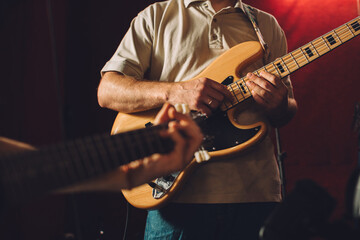 Obraz premium Musicians playing bass and electric guitars during recording session