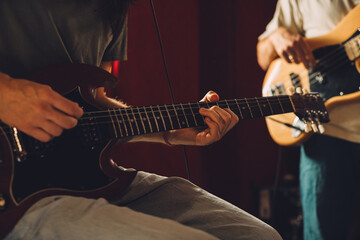 Obraz premium Guitarist playing electric guitar in recording studio with bass player