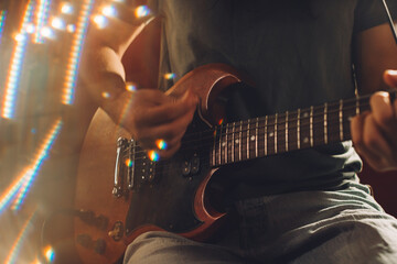 Musician playing electric guitar in recording studio with lens flare