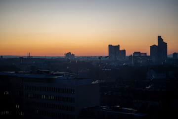 Cologne city skyline with glowing buildings at dawn.