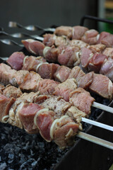 Fresh meat on a metal skewer. Fresh meat cooked at barbecue. BBQ fresh beef meat chop slices. Shish kebab on skewer. Meat cooked over fire