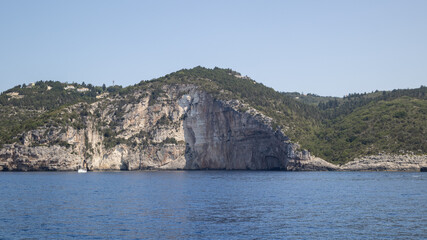 seaside cliff landscape, lush green hills, clear blue sea, mediterranean coast