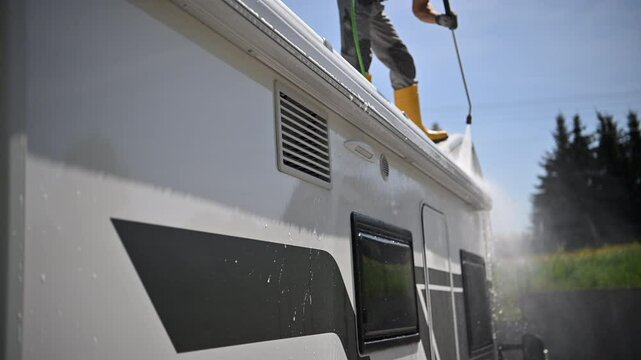 Cleaning a Campervan Exterior With Water and Soap in a Sunny Outdoor Setting