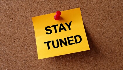 stay tuned text on post it paper pinned on the bulletin cork board
