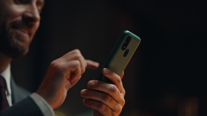 Night businessman hands touching smartphone online shopping in office closeup