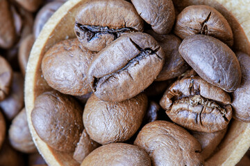 Macro photo of coffee beans in a wooden spoon.
