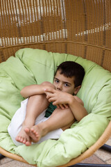 Cozy Young Boy Nestled in Rattan Chair at Home