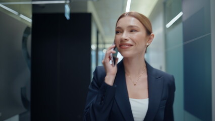 Smiling director negotiating smartphone on go at corridor closeup. Woman calling