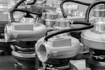 Several turbochargers arranged neatly in a workshop highlight the complexity and precision of modern automotive engineering during daylight hours.