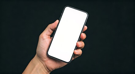 Hand holding a modern smartphone with a blank white screen against a dark background for easy customization.