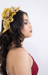 Right profile portrait of a young Colombian woman wearing a red dress against a white background in...