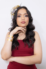 Tempting gaze of a beautiful young Latina woman standing in a red dress against a white background...