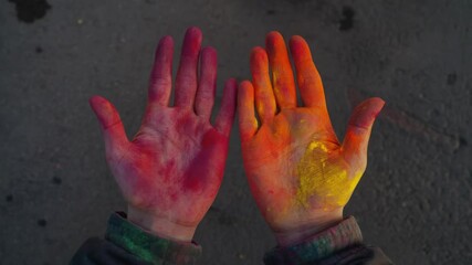 Celebrating the Holi festival with hands smeared in colorful powders. A joyous Indian event that symbolizes the victory of good over evil.