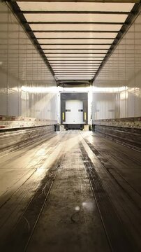 Clean, Empty Truck Trailer Awaits Loading: Rear Door Open to Dock at Days End, Ready for New Cargo and Transport Operations after Sweeping
