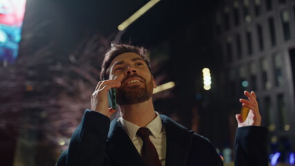 Overjoyed manager calling night business district closeup. Happy man talking