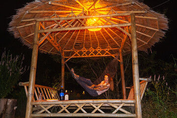 Vacation in Thailand in bugalow. Sea, beach, tropical fruits and drinks. Fit couple in hammock.
