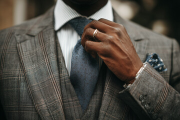 Man adjusting his tie a stylish in a suit a confident man