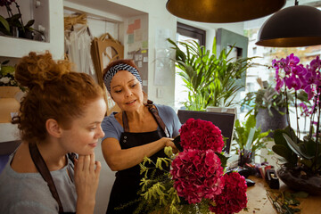 Mother and daughter florists working with flower arrangement in a shop