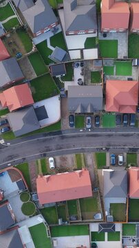 Vertical top down aerial view of new build houses in the United Kingdom. Housing market. Suburban lifestyle.	