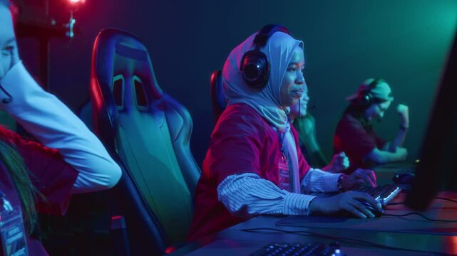 Medium shot of joyous multinational female cybersport team members giving each other high fives and cheering, after successfully passing level in online multiplayer shooter game