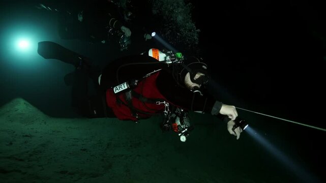 Two divers explore the dark, underwater cave system beneath Budapest. They use lights to illuminate the passageways while following a safety line. An incredible adventure unfolds.