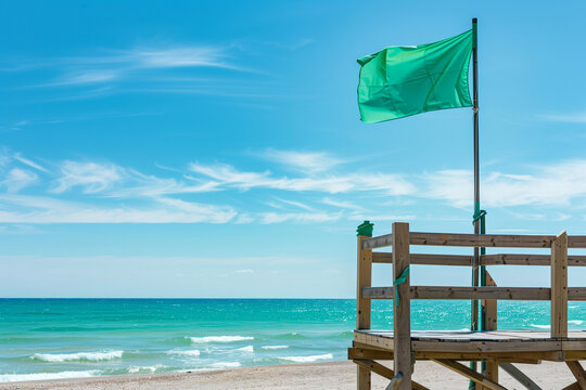 Green Flag Flies Above Lifeguard Station Indicating That the Sea Is Calm and Swimming Is Safe for Tourists