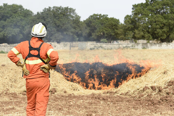 pompiere in piedi osserva un incendio spento