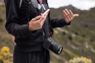 A woman with a camera around her neck pauses to meditate and breathe deeply, soaking in the tranquil beauty of her surroundings. A perfect moment of peace and connection with nature.


