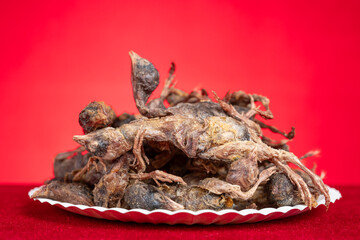 dish of freeze-dried quails at cats treats on a red background