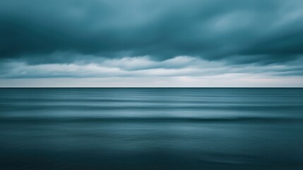 Obraz premium Serene Ocean Waves Under Dark Cloudy Sky, Calm Seascape with Gentle Ripples Reflecting the Moody Atmosphere