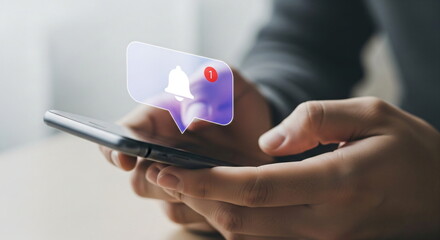 Man holding a smartphone with a notification bell icon. New social media message concept for digital communication.