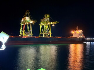 ship loading coal by the shore cranes
