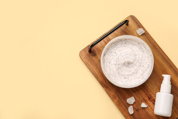 Wooden board with jar of body scrub and cosmetic product on color background