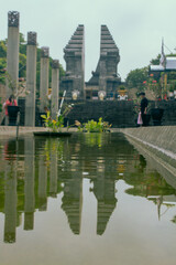 Naklejka premium Soekarno’s Tomb Entrance with Serene Fish Pond and Lush Garden on Sunny Day