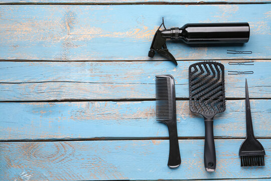 Hairdresser's brushes with spray on blue wooden background - Powered by Adobe