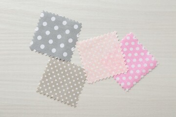 Samples of different fabrics on white wooden table, flat lay